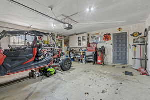 Garage featuring a garage door opener and a workshop area