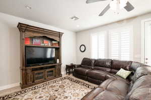 Living room featuring ceiling fan and light tile patterned floors