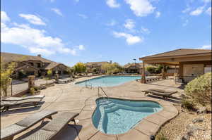 View of swimming pool with a patio and an in ground hot tub