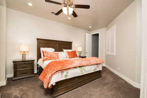 Bedroom with ceiling fan and dark carpet