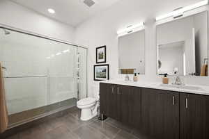 Bathroom with walk-in shower featuring penny-tiled floor and subway-tiled walls, floating adult-height vanity with undermount sink.