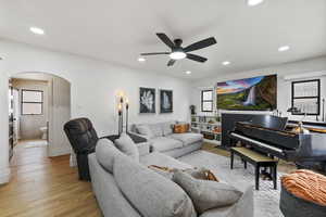 Living room with ceiling fan and light hardwood / wood-style floors