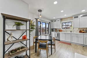 Kitchen featuring pendant lighting, sink, plenty of natural light, and dishwasher