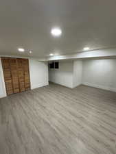 Basement with light hardwood / wood-style floors