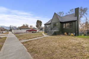 View of front of house featuring a mountain view and a front yard