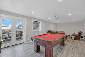 Game room with billiards, light hardwood / wood-style floors, and french doors