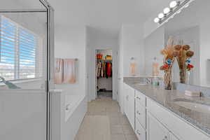 Bathroom with tile patterned flooring, vanity, and a shower with shower door