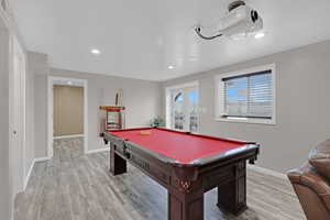 Recreation room with billiards, light hardwood / wood-style floors, and a textured ceiling