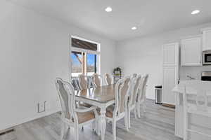 Dining area with light hardwood / wood-style flooring