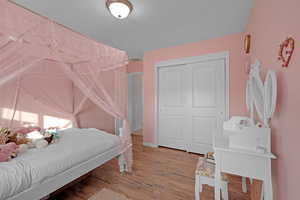 Bedroom featuring hardwood / wood-style floors and a closet