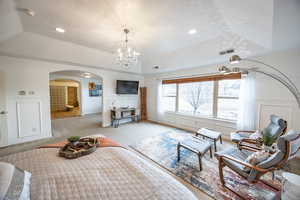 Master suite featuring an inviting chandelier, light colored carpet, tray ceiling and sitting area in bedroom