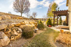 View of yard with a wooden deck and a pergola