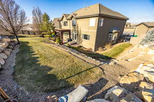 Rear view of house with lawn and a pergola