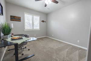 Carpeted office /bedroom with ceiling fan on main level