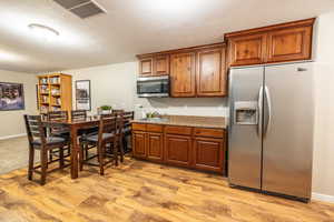 Basement kitchenette with wood-style floors, stainless steel appliances, and pantry