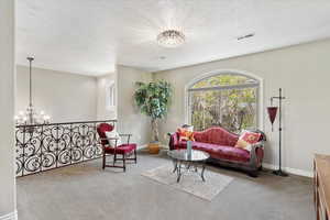 Living area featuring a notable chandelier, visible vents, and a healthy amount of sunlight