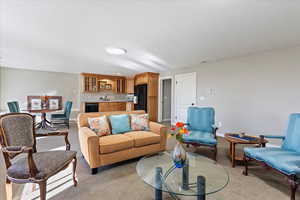Living area with indoor bar, light carpet, and baseboards