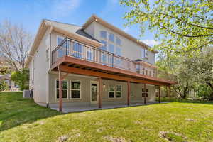Rear view of property featuring a yard, a patio, stucco siding, and a deck