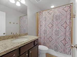 Full bathroom with tile patterned flooring, vanity, shower / tub combo, and toilet