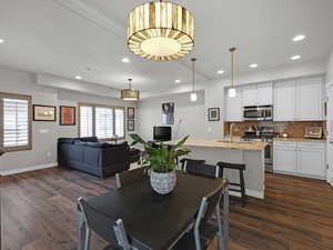 Dining area with sink and dark wood-type flooring