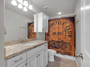 Bathroom with vanity, tile patterned floors, and toilet