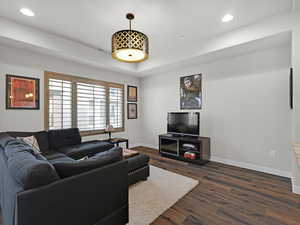 Living room with a raised ceiling and dark hardwood / wood-style floors