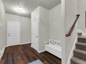 Foyer with a textured ceiling and dark hardwood / wood-style flooring