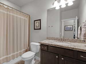 Full bathroom featuring vanity, shower / bath combo with shower curtain, and toilet