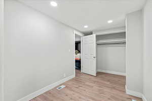 Unfurnished bedroom with a closet and light hardwood / wood-style flooring