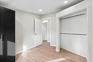 Unfurnished bedroom with light hardwood / wood-style floors and a closet