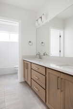 Full bathroom featuring tile patterned flooring, vanity, tiled shower / bath combo, and toilet