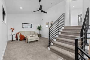 loft with light carpet, high vaulted ceiling, and ceiling fan