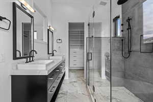 2nd primary bathroom featuring vanity, shower and entry to walk in closet