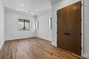 Unfurnished bedroom with light hardwood / wood-style flooring and a closet