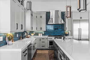 Kitchen showcasing European style cabinetry, farm sink, and backsplash.