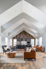 Living room featuring lofted ceiling, light wood-type flooring, and a wealth of natural light