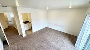 Unfurnished bedroom featuring ensuite bath and carpet flooring