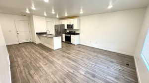 Kitchen featuring sink, white cabinetry, light wood-type flooring, appliances with stainless steel finishes, and kitchen peninsula