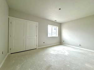 Unfurnished bedroom with a closet and a textured ceiling