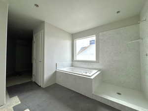 Bathroom with shower with separate bathtub and a textured ceiling