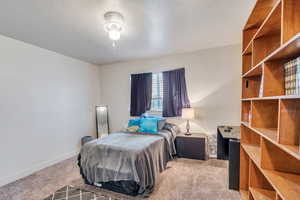 Bedroom featuring light carpet and a textured ceiling