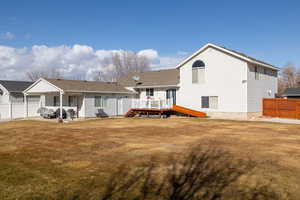 Rear view of house featuring a yard and a deck