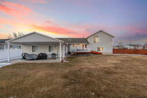 View of front of home with a yard, a patio area, and a deck