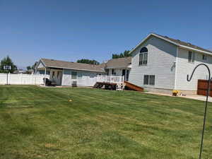 Rear view of property with a yard and a deck