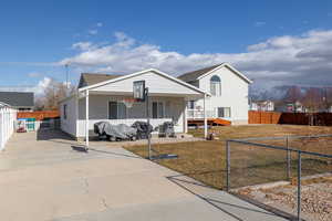 View of front facade with a mountain view, a front yard, and covered porch