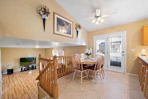 Tiled dining room with vaulted ceiling and ceiling fan