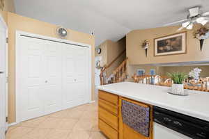 Kitchen with light tile patterned flooring, lofted ceiling, ceiling fan, and white dishwasher