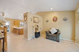 Sitting room with lofted ceiling, light tile patterned floors, and ceiling fan