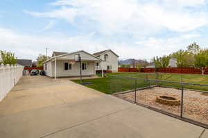 View of front of house with fence private yard, driveway, and a front lawn