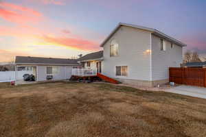 View of front of house with a lawn, a deck, and a patio area